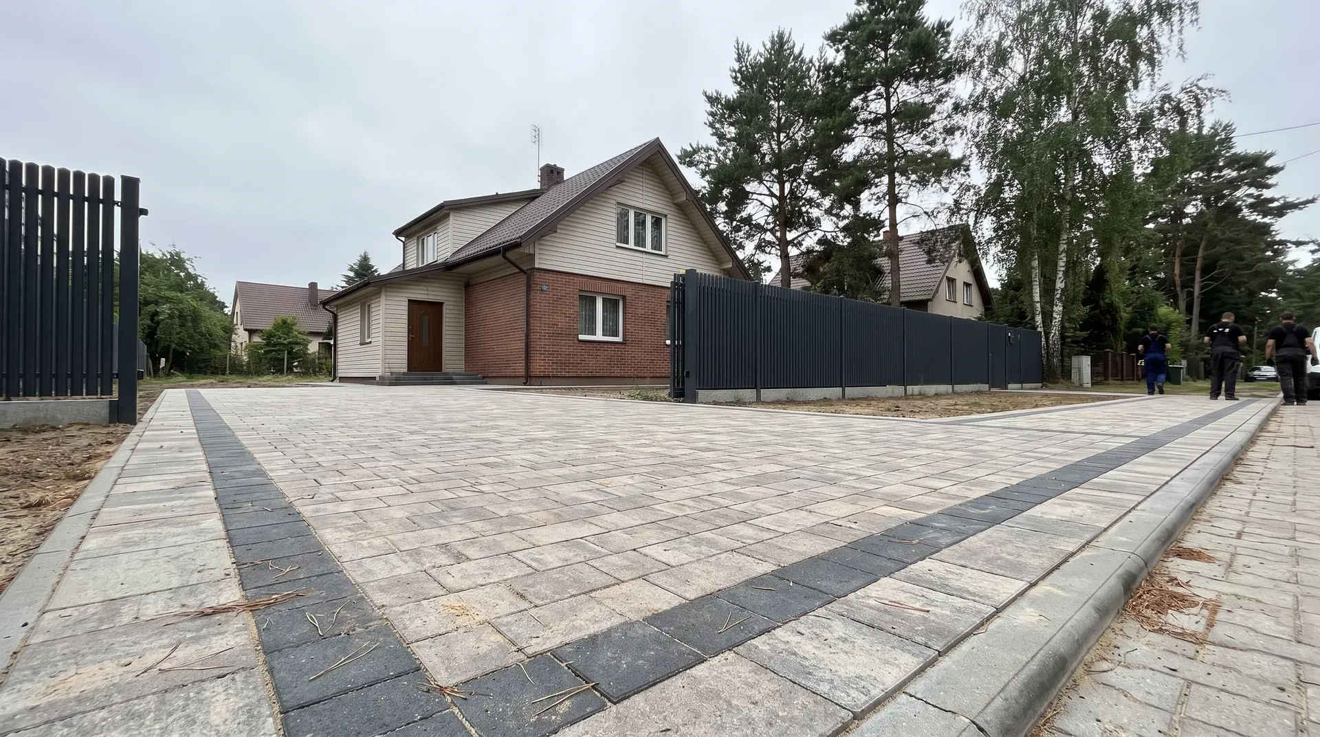 Dom przy bocznej ulicy w Markach z nowym podjazdem z szarej kostki