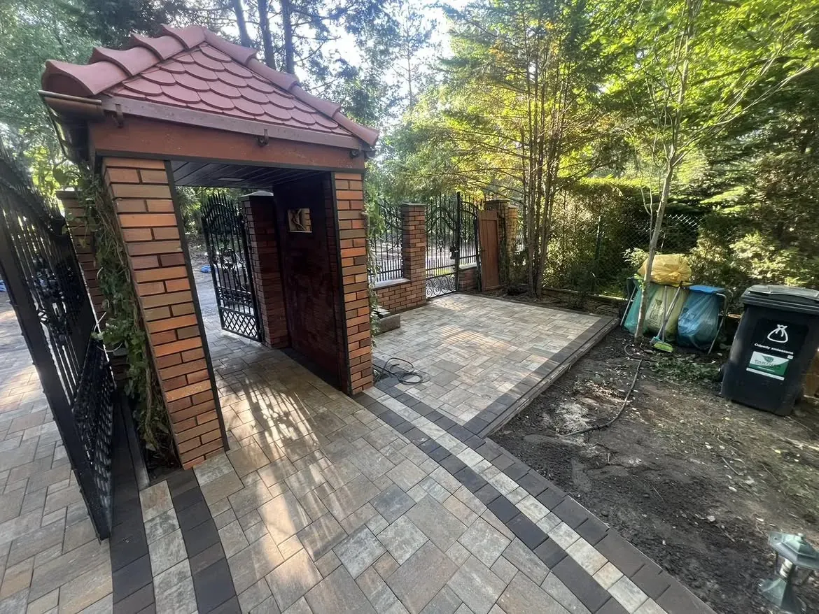 Chodnik z kostki betonowej przy murowanej furtce z daszkiem