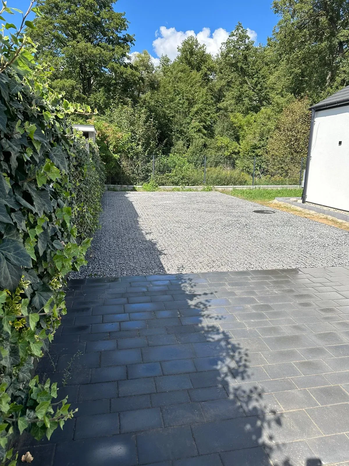 Nawierzchnia z grafitowej kostki betonowej przechodząca w plac z kruszywa