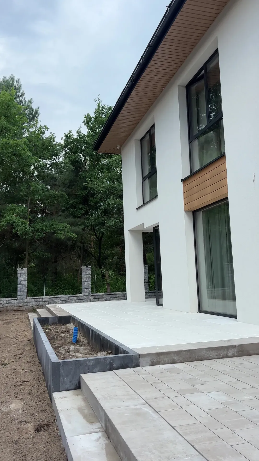 Podest tarasu z płyt wielkoformatowych z donicą obłożoną ciemnymi płytami