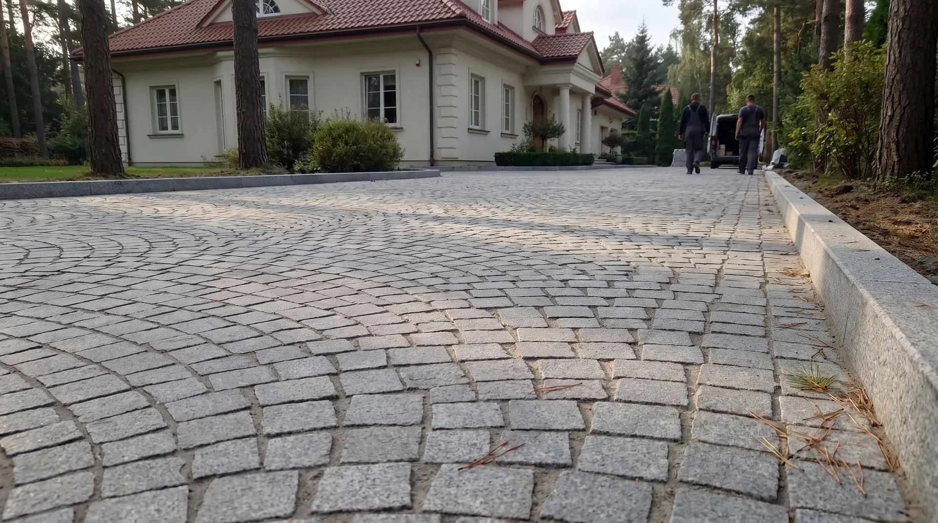 Podjazd z szarej kostki granitowej ułożonej w wachlarze przed willą pod Warszawą